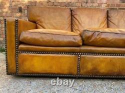 A Huge Four seater vintage Tan leather sofa with studs Made in England